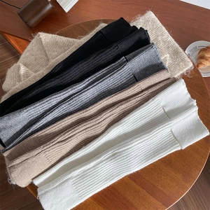 Jambières en maille côtelée verticale de diverses couleurs sur une table en bois