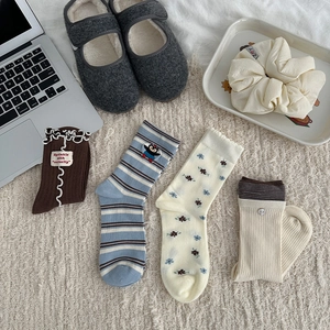 Flat lay of four floral and striped cotton crew socks with ruffles and embroidery