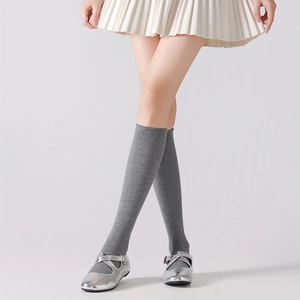 Detail of grey cotton knit knee high socks with soft ribbed texture on model