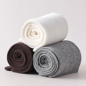 Detail of wool knit calf socks in white, brown, and gray with warm ribbed texture