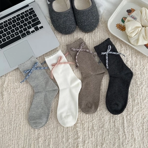 Détail de quatre paires de chaussettes en coton avec dentelle et nœud à carreaux