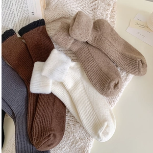 Detail of colorful thick thermal socks showing plush interior texture on a soft blanket