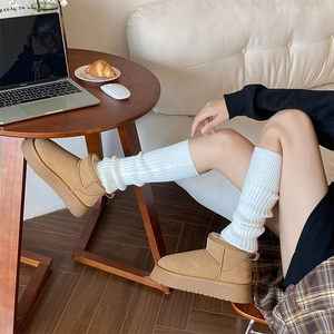 Stivali beige con zeppa e scaldamuscoli in maglia bianca per un calore invernale