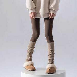 Women's khaki knit leg warmers paired with brown snow slippers for autumn winter warmth