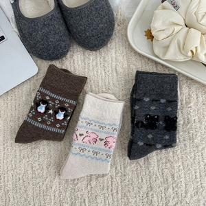 Detailed knit texture of three pairs of thick wool socks with cute animal patterns