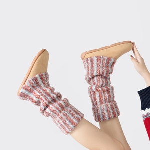 Détail de jambières en tricot rayé avec semelles douces en suède au style minimaliste
