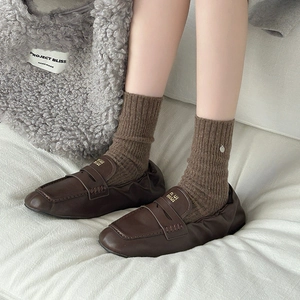 Detail of dark brown leather loafers with elastic heel and ribbed knit wool socks