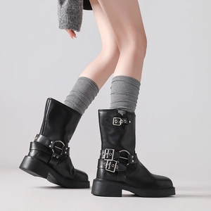 Detailed view of black biker boots with metal buckles and gray wool knit leg warmers