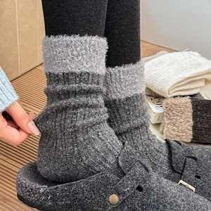 Detail of warm winter knit socks with faux fur trim and elastic texture in dark grey