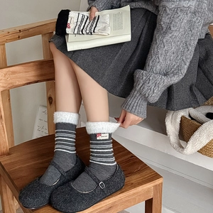 Detail von dunkelgrauen Streifensocken mit weißem Fleece-Rand und Pilz-Aufnäher