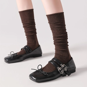 Brown wool knee high socks paired with black Mary Jane shoes for a stylish vintage look