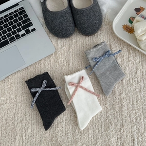 Gros plan détaillé de trois paires de chaussettes style collège avec volants et nœuds