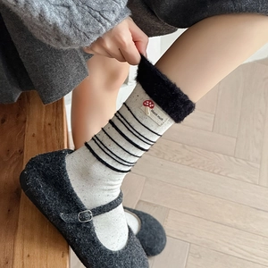 Detailaufnahme der Strick-Socke mit schwarzem Kunstfellbesatz und Pilz-Stickerei-Aufnäher