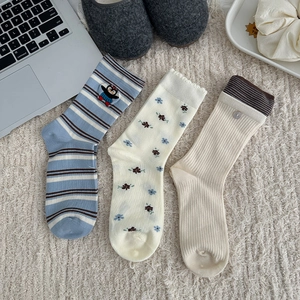 Detailed set of three cotton crew socks with floral patterns and cute animal embroidery