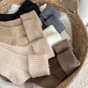 Detail of knitted ribbed socks in earthy tones showing soft texture and thick wool blend