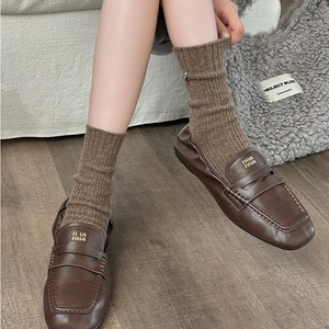 Women's thick wool socks in brown paired with leather loafers for cozy autumn style