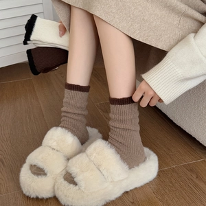 Plush faux fur open-toe slippers paired with warm thermal knit socks for cozy home wear