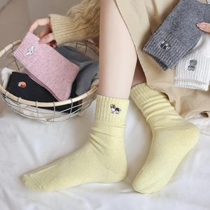 Detail of cute animal embroidery on warm ribbed knit crew socks in various soft colors