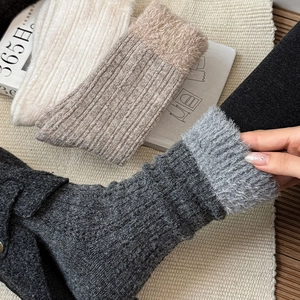 Detailed close-up of thick ribbed knit texture and fuzzy plush cuffs on winter socks