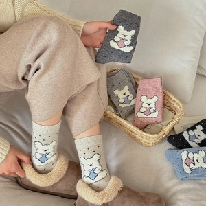 Close-up of thick knit crew socks with cute cartoon bear patterns in multiple colors
