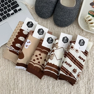 Détail de cinq paires de chaussettes ours marron sur un tapis en peluche doux
