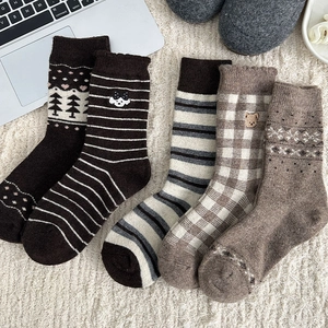 Flat lay of five pairs of vintage brown striped wool socks with cute animal embroidery