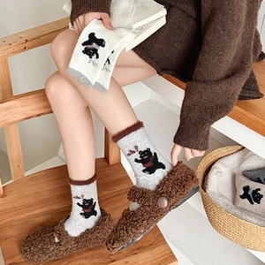 Thick wool socks with cartoon bear pattern and plush cuffs paired with fuzzy slippers