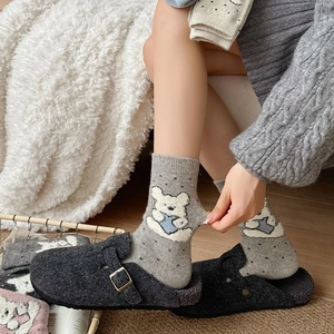 Cozy gray polka dot socks with bear patterns and wool felt clogs on soft rug
