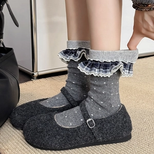 Detail of dark grey Mary Jane shoes paired with polka dot lace trim wool socks
