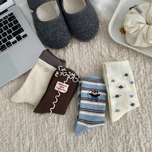 Selection of sweet floral and striped crew socks displayed on a cozy beige carpet