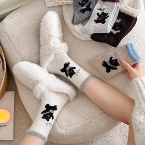 Detail of wool socks featuring cute bear patterns and fuzzy plush cuffs for winter warmth