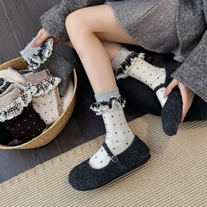 Close-up of vintage wool socks featuring lace edges and checkered double-layered cuffs