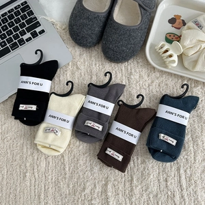 Detailed view of five-pack ribbed cotton socks with bow labels in neutral tones