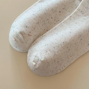 Makro-Detail des Retro-Strickgewebes mit bunten Farbtupfern und Rippenstruktur der Socken