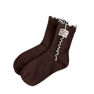 Dark brown mid-calf knit socks with white scalloped edges and a decorative textile tag