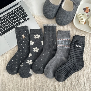 Detailed knit patterns on gray wool socks including polka dots and embroidery
