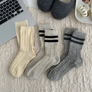 Detailed knit texture of wool socks in beige and grey with vintage cable patterns