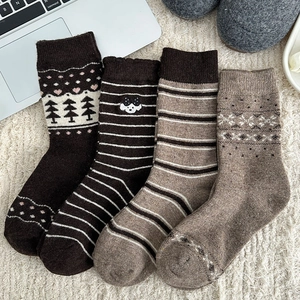 Detail of four pairs of thick wool socks with Nordic patterns and cute dog embroidery