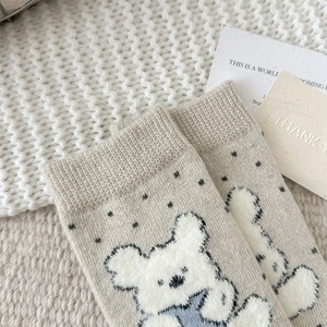 Close-up of thick knitted bear socks with polka dots and ribbed cuffs for winter