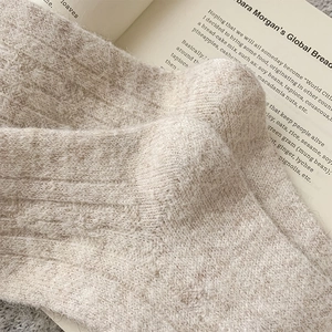 Detailed macro texture of warm oatmeal wool socks with soft knitted ribbing detail