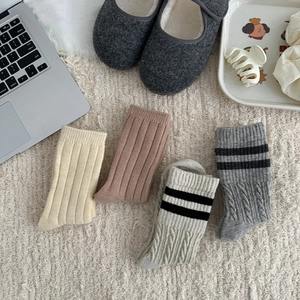 Detailed knit textures of vertical ribbed and cable wool socks in neutral autumn colors