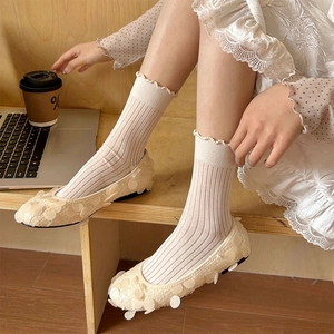 Ballerines plates à paillettes blanches avec chaussettes à froufrous sur bois