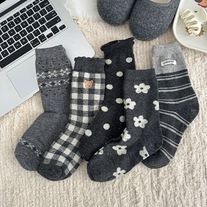 Close-up of five pairs of wool blend socks with Nordic patterns and bear embroidery