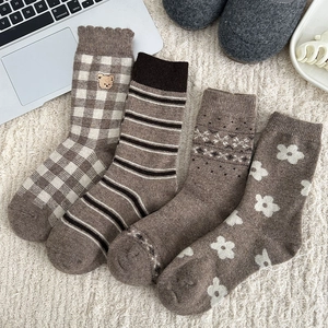 Set of four brown wool-blend socks featuring striped, plaid, and floral embroidery patterns