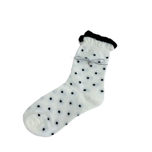 Chaussettes blanches à pois noirs avec bordure en dentelle et détails de nœud argenté