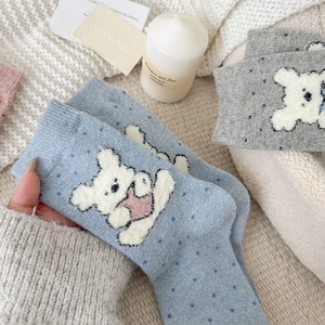 Detailed close-up of knitted crew socks with cute bear patterns and polka dots