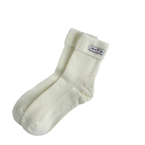 White ribbed knit slouch socks with small cloth label shown on plain white background
