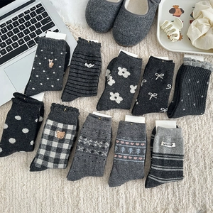 Flat lay of gray Fair Isle wool socks with bear embroidery and heart patterns