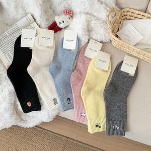 Close-up of cute cartoon animal embroidery on colorful knitted wool blend crew socks