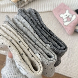 Close-up of thick knitted crew socks with polka dots in white and grey tones